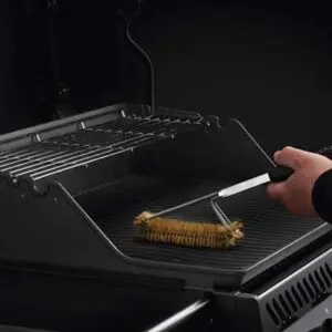 Grillrost, der mit einer Grillbürste gereinigt wird